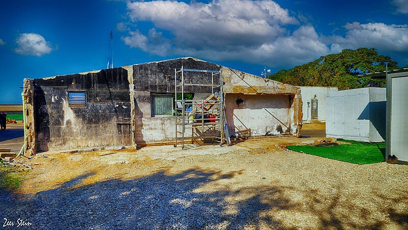 קיר שרוף, ששרד את הטבח, במגורי עובדי הרפת התאילנדים בעלומים, והקיבוץ מייעד להנצחתם