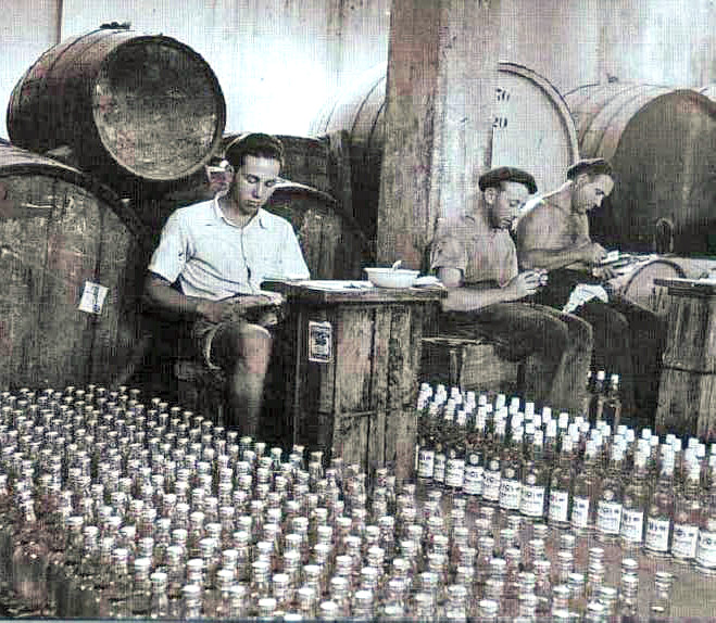 רישום הבקבוקים, ברקע חביות היין,  יקב פרידמן, שנות ה-40, מארכיון פתח תקוה