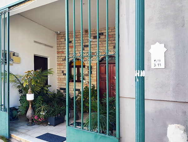 שלט צורני שהותיר את מספר הבית ורקע לבן בלבד [מימין], ביתו של ראש המועצה המקומית