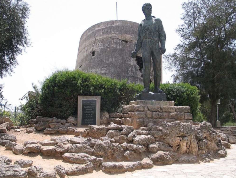 אנדרטה שיצר נתן רפפורט, לזִׁכרו של מרדכי אנילביץ׳, ממנהיגי מרד גטו ורשה, על רקע מגדל המים המחורר ממלחמת העצמאות, קיבוץ יד מרדכי, 2006